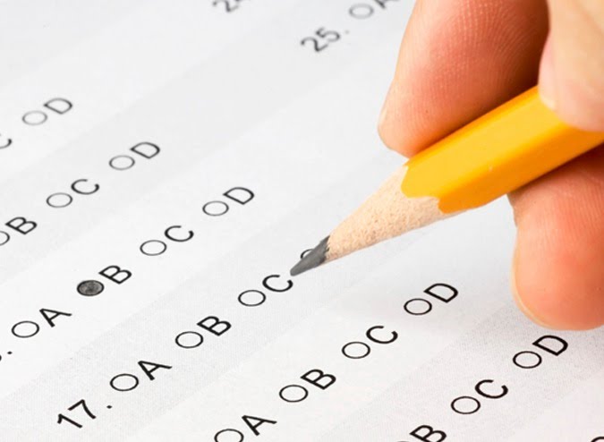 Person completing a multiple choice exam paper